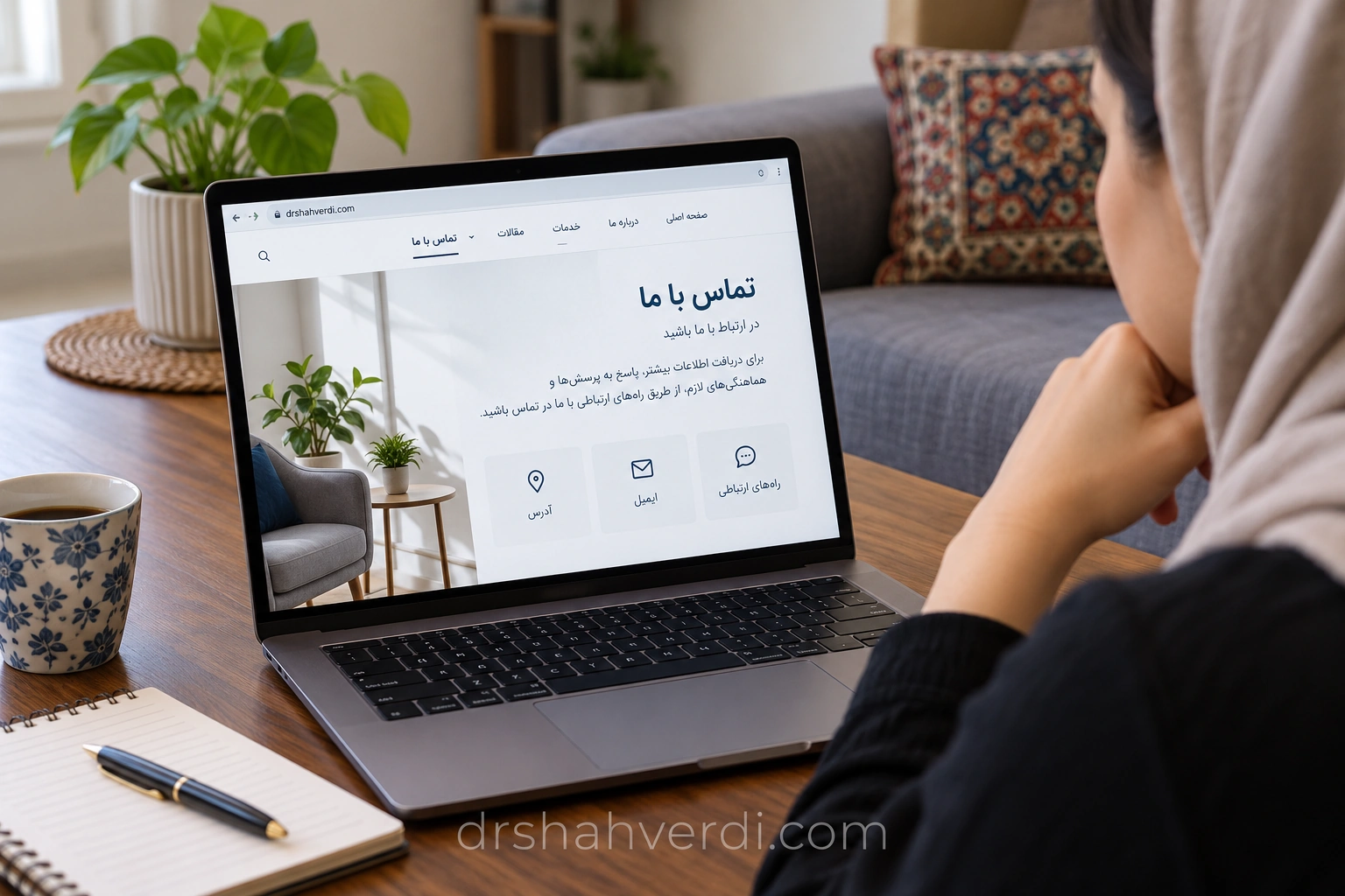 فردی در خانه صفحه تماس وب‌سایت را روی لپ‌تاپ می‌خواند
